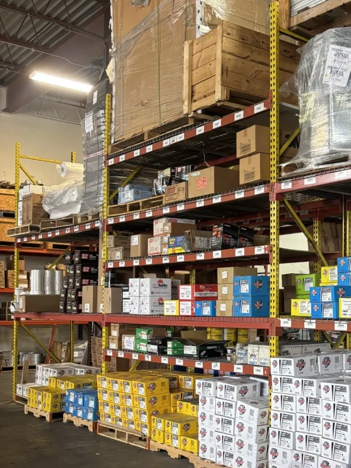 Warehouse shelves stocked with various boxed items and pallets.