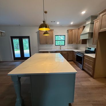 Modern kitchen with a large island and wooden cabinets.