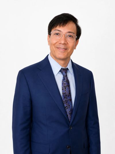 Man in blue suit smiling at the camera.