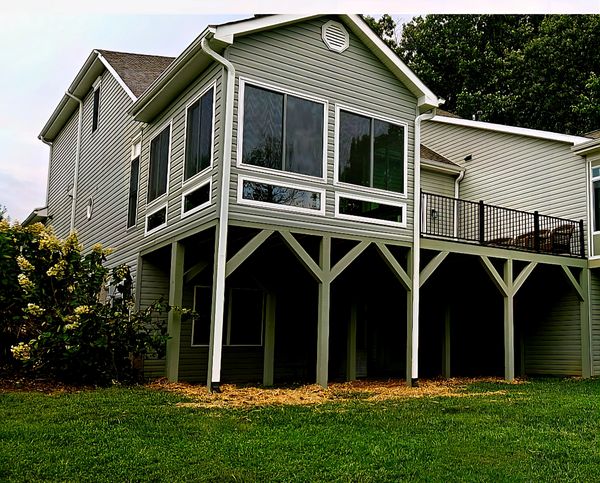 Modern house with large windows and elevated deck.