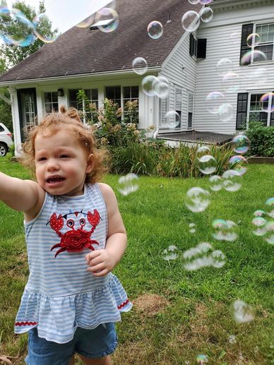 Granddaughter with wand, blowing soap bubbles