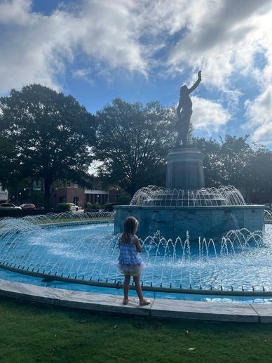 Granddaughter at base of big stone fountain