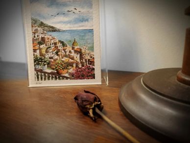 Single dried rose lying on top of an antique cabinet