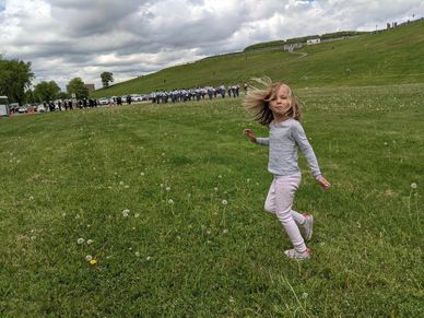 A granddaughter twirling on the lawn at the Citadel in Halifax, bagpipe and drum corps in background