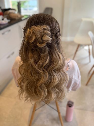 Long wavy hair styled with a braid and a twisted bun at the back.