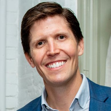 Smiling man in a blue jacket.