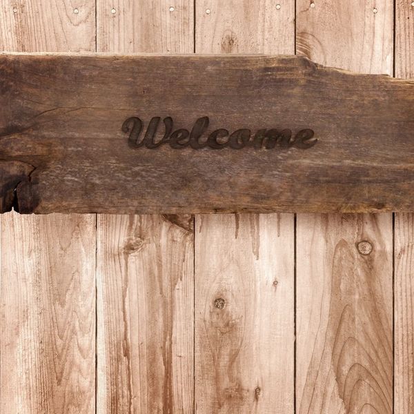 A wooden welcome board. A rustic image to welcome people to our about page.