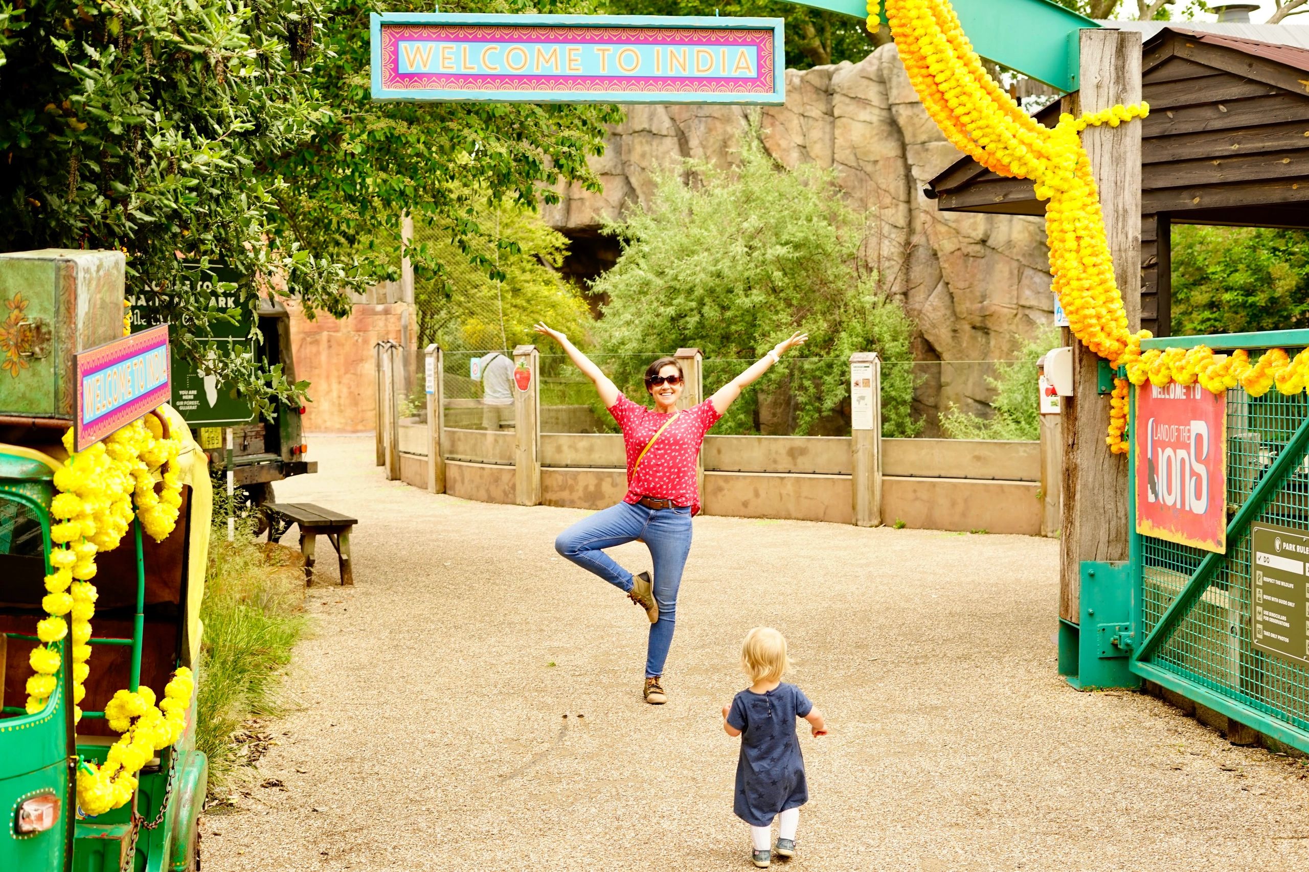 Helen in Tree Pose under Welcome to India sign