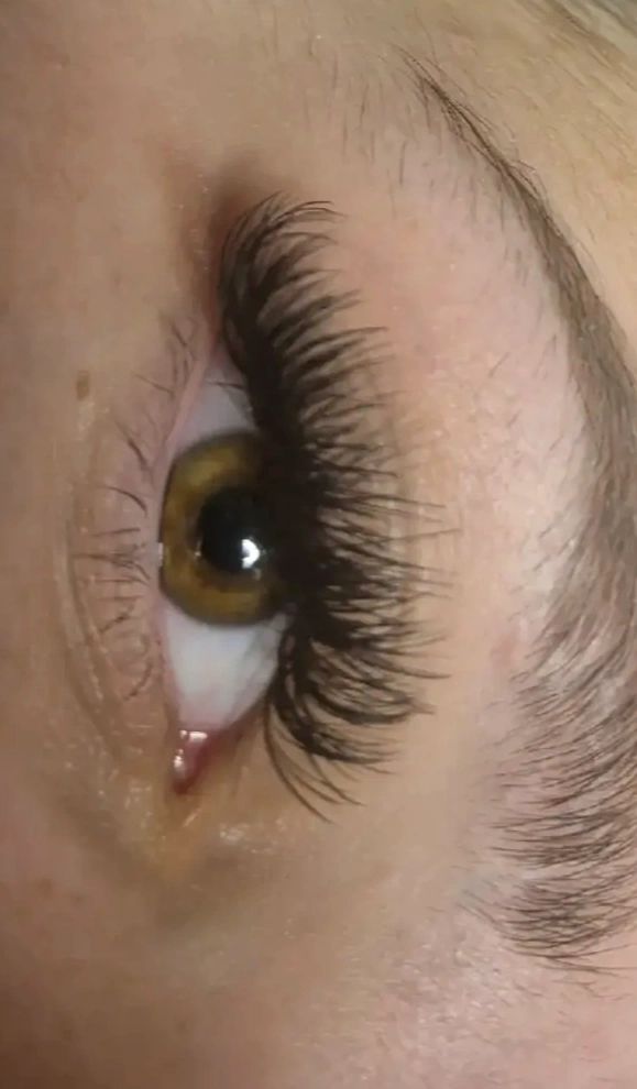 Close-up of an eye with thick eyelashes.