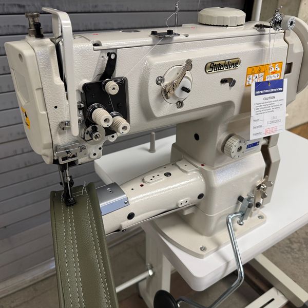 Industrial Stitchline sewing machine stitching heavy green fabric.