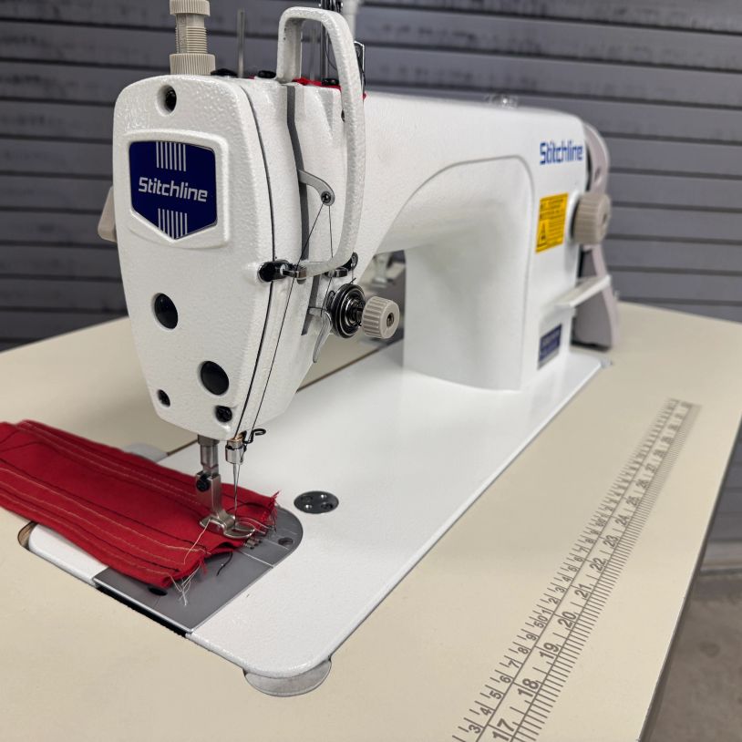 White Stitchline sewing machine with red fabric being stitched.