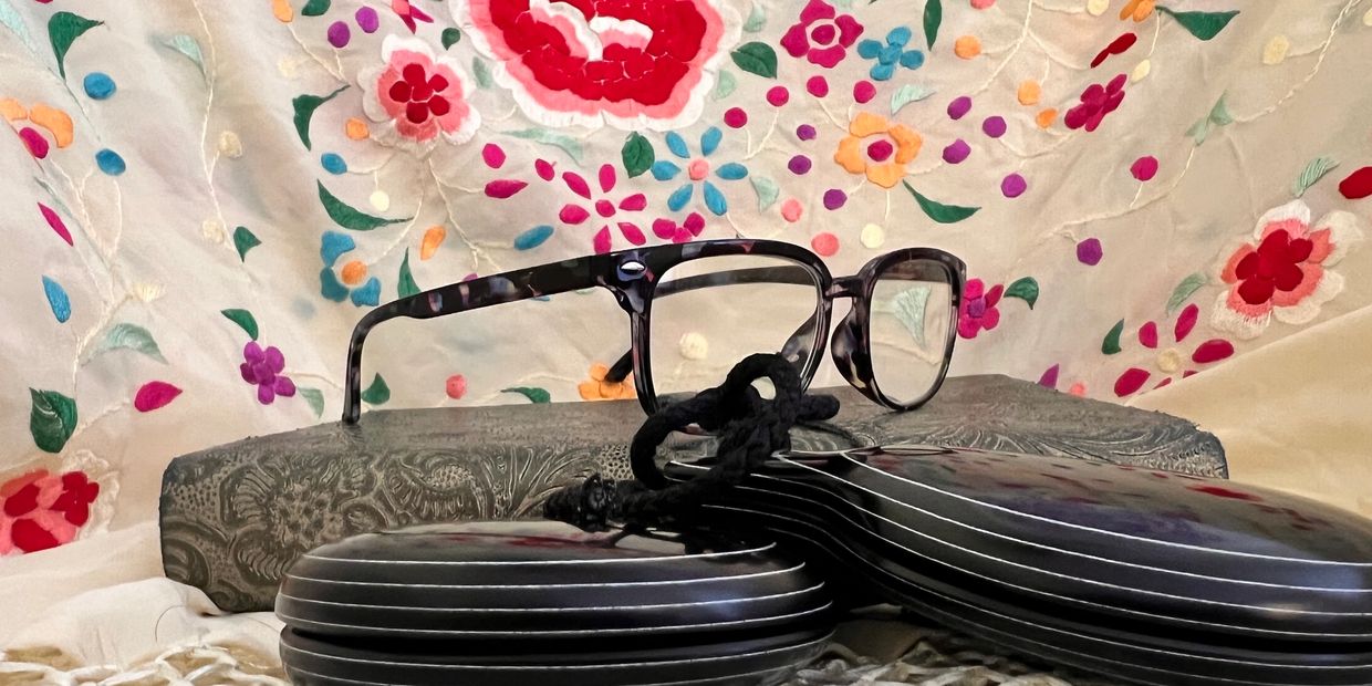 Eyeglasses resting on a decorative surface with a Flamenco Dance Shawl