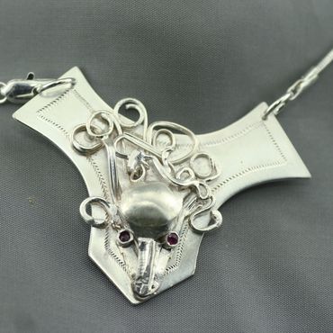 This 20" sterling silver necklace features a collage creature with ruby eyes and sterling chain.