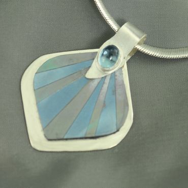Sterling silver and titanium pendant featuring blue topaz.  Does not include chain.