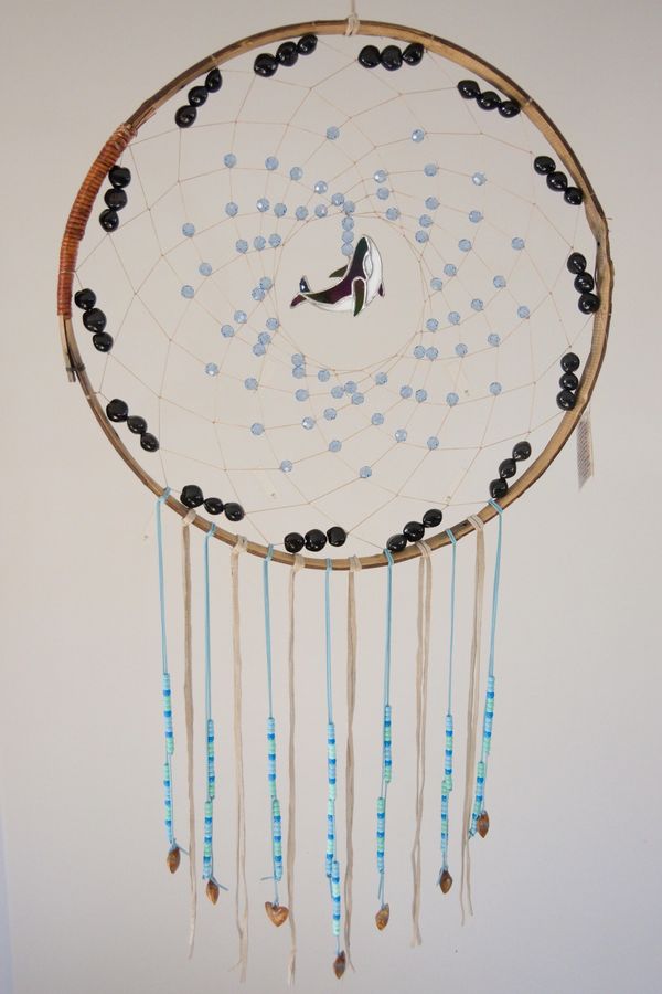 Handcrafted dreamcatcher with beads and a whale centerpiece.