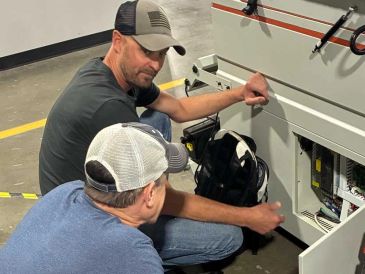 Two men working on industrial equipment.