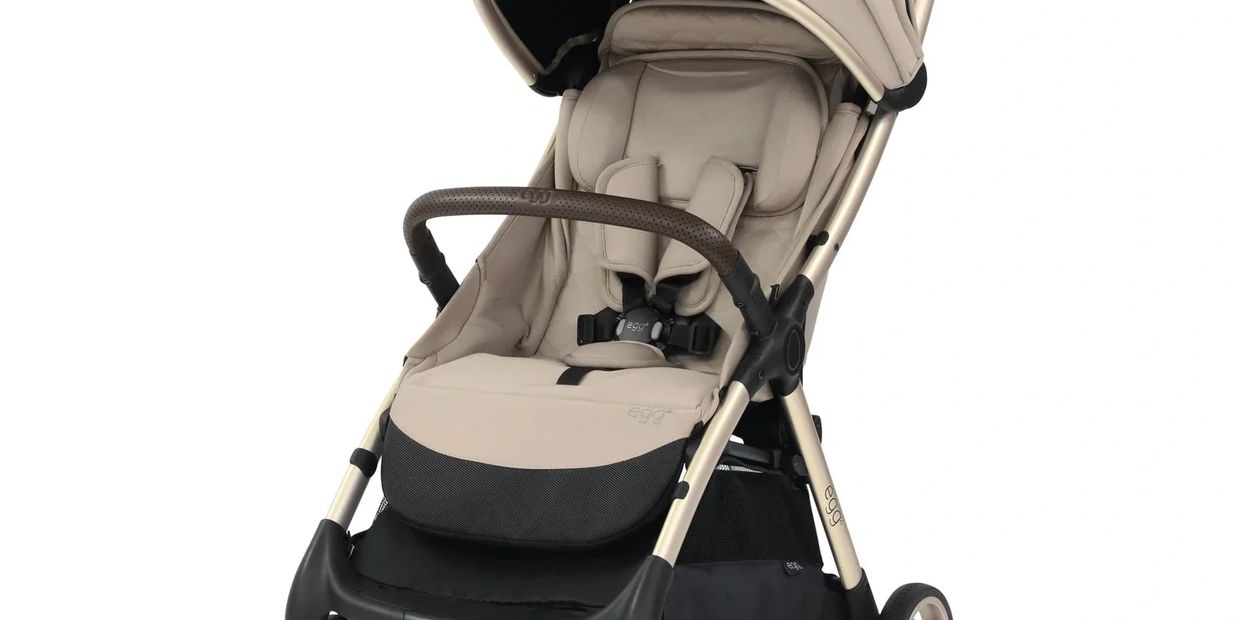 Beige and black baby stroller with comfortable padding and sturdy frame.