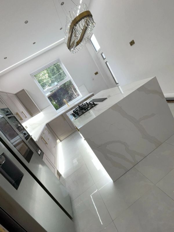 Modern kitchen with marble countertops and gold accents.