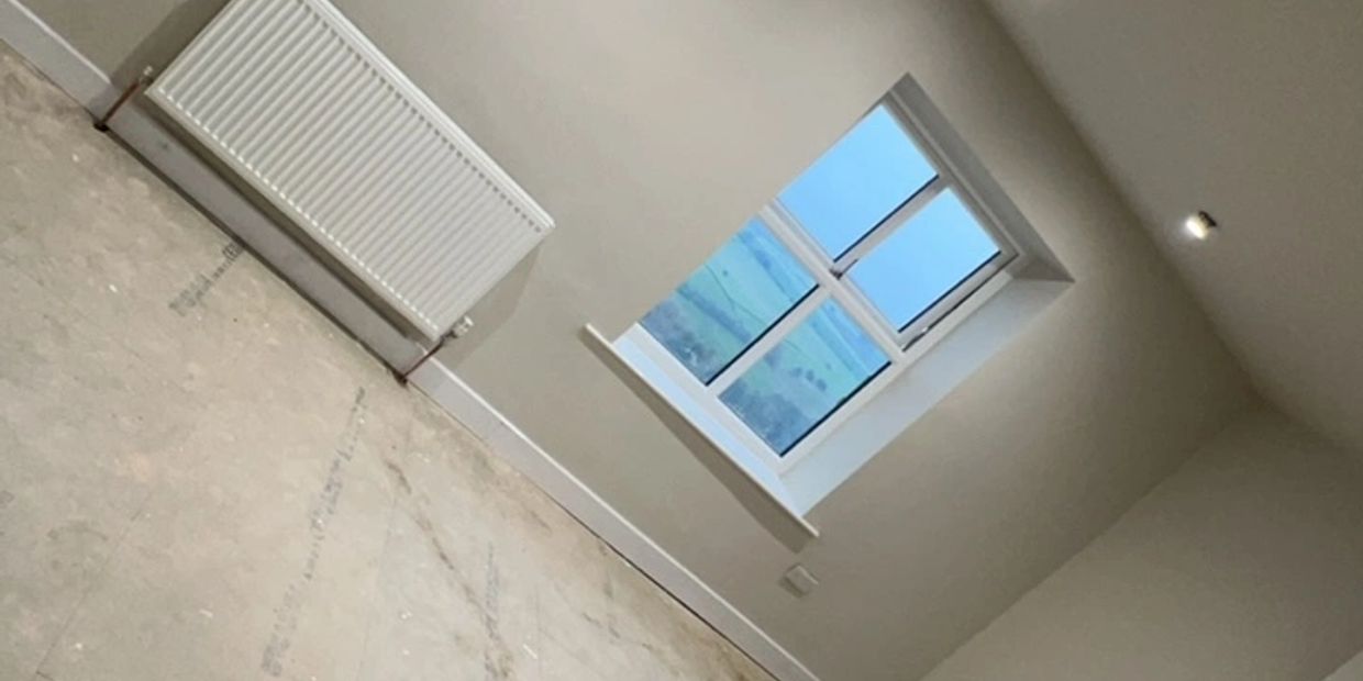 Empty room with a window showing a countryside view.
