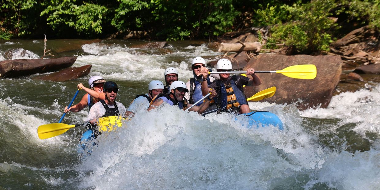 Group white-water rafting through rapids.