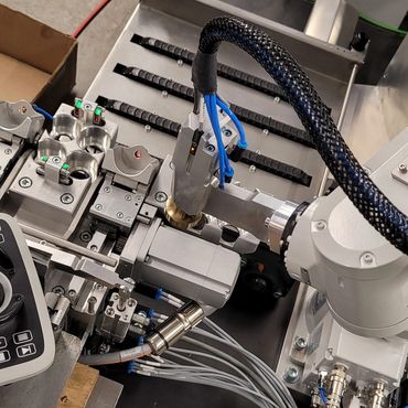 Close-up of a robotic arm working on a mechanical assembly.