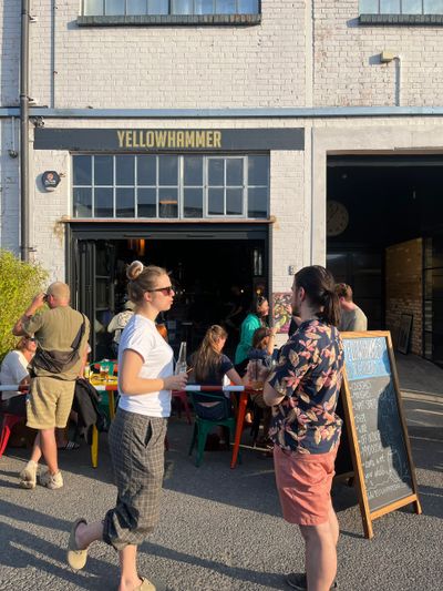 People chat outside Yellowhammer, a casual eatery on a sunny day.