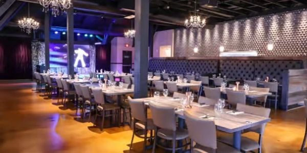 Modern restaurant interior with elegant lighting and neatly arranged tables.