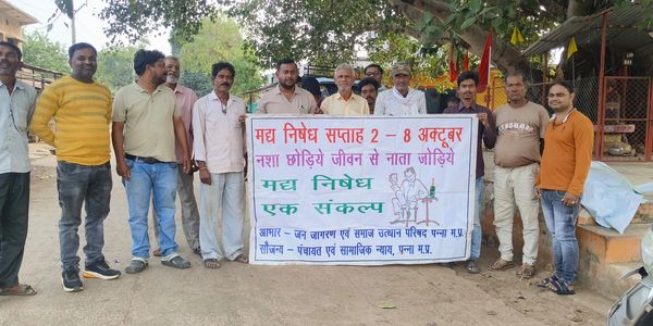 Group of men holding a banner for an anti-alcohol awareness week in Hindi.