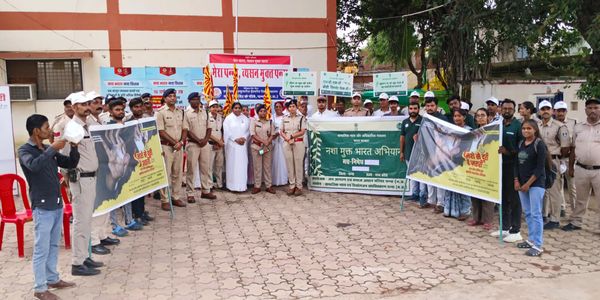 Group of people, including police and civilians, holding banners for a community awareness event.
