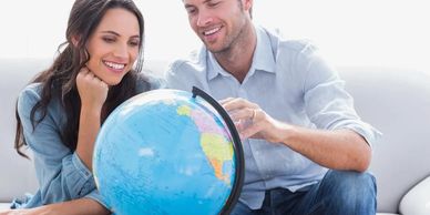 A couple smiling looking at globe
