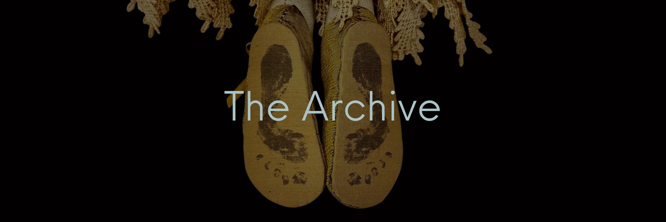 Worn ballet slippers with footprints and 'The Archive' text.
