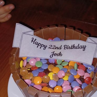 A birthday cake decorated with candy and a message for Josh's 22nd birthday.
