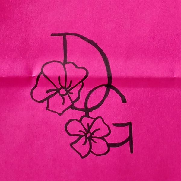 Black floral design intertwined with letters D and G on pink paper.