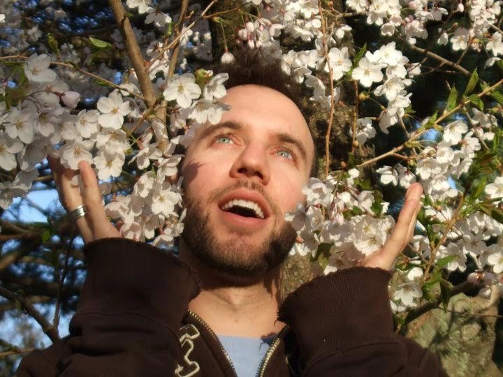 Man enjoying spring blossoms around his face.