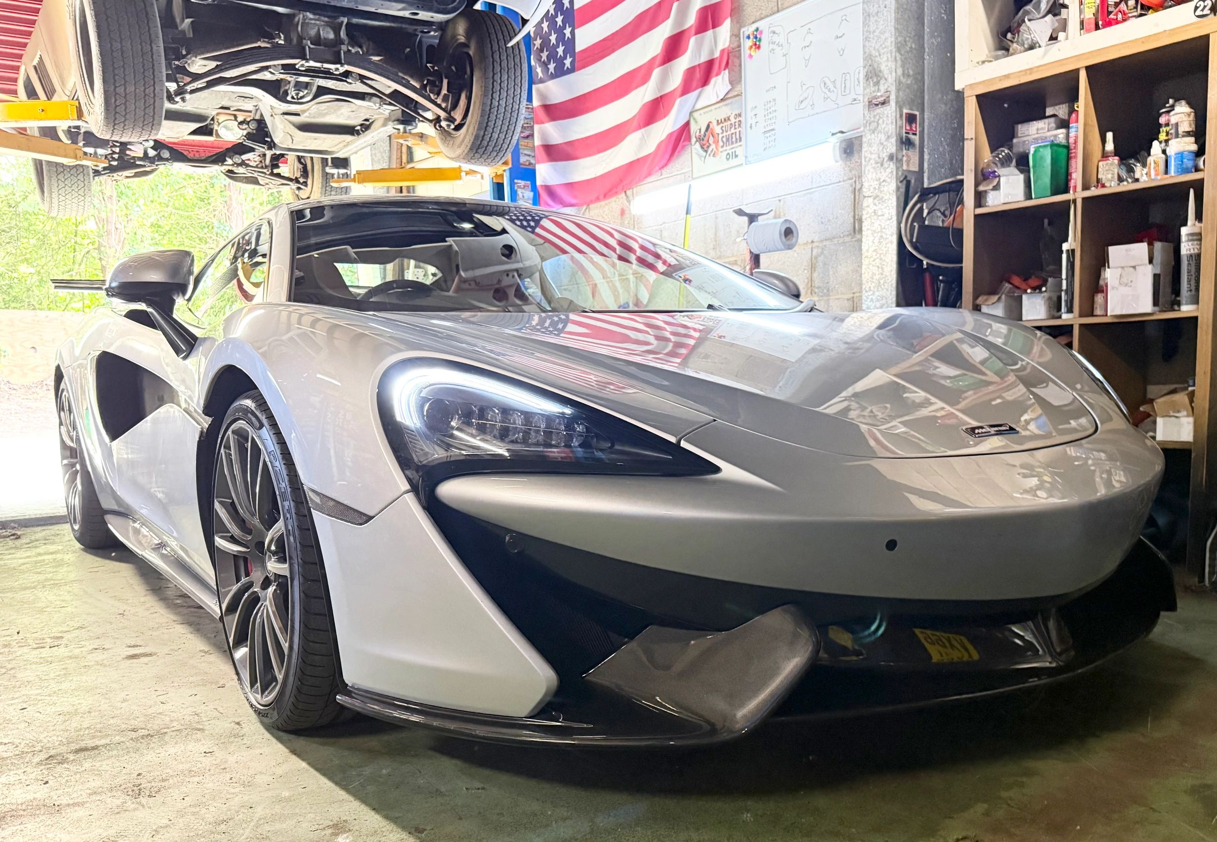 Silver McLaren sports car in a garage.