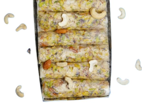 Box of Indian dry fruit sweets garnished with cashews and almonds.