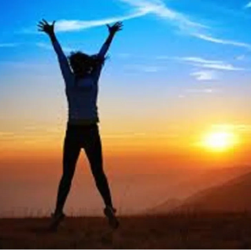 a person with hands up and a sunset view 
