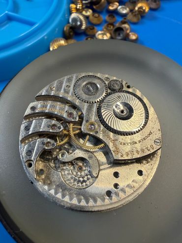 Close-up of a vintage watch movement with visible gears and screws.