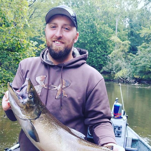 Man holding a large fish on a boat.