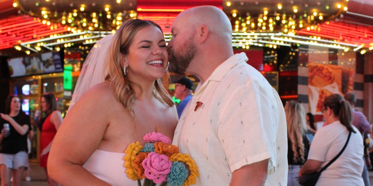 Couple sharing a joyful moment under a bright casino sign.