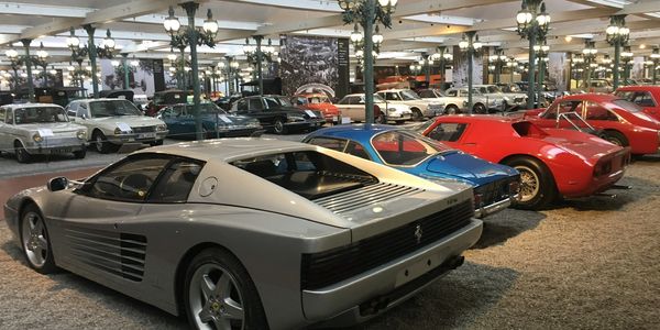 A collection of vintage and classic cars in a well-lit indoor museum.