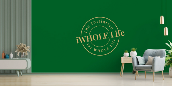 An inviting space with a chair and tables and the iWHOLE Logo as a backdrop