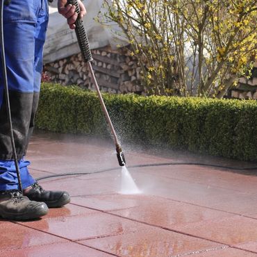 a man pressure washing exterior tiles