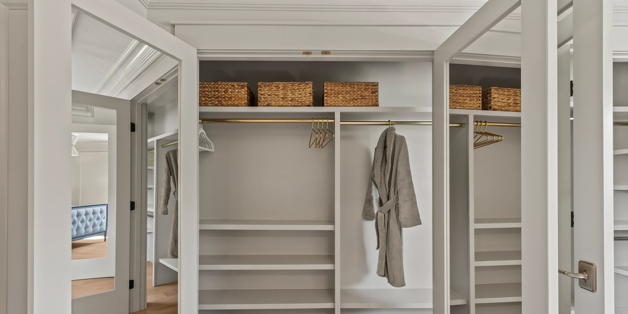 Modern empty wardrobe with open doors and shelves.