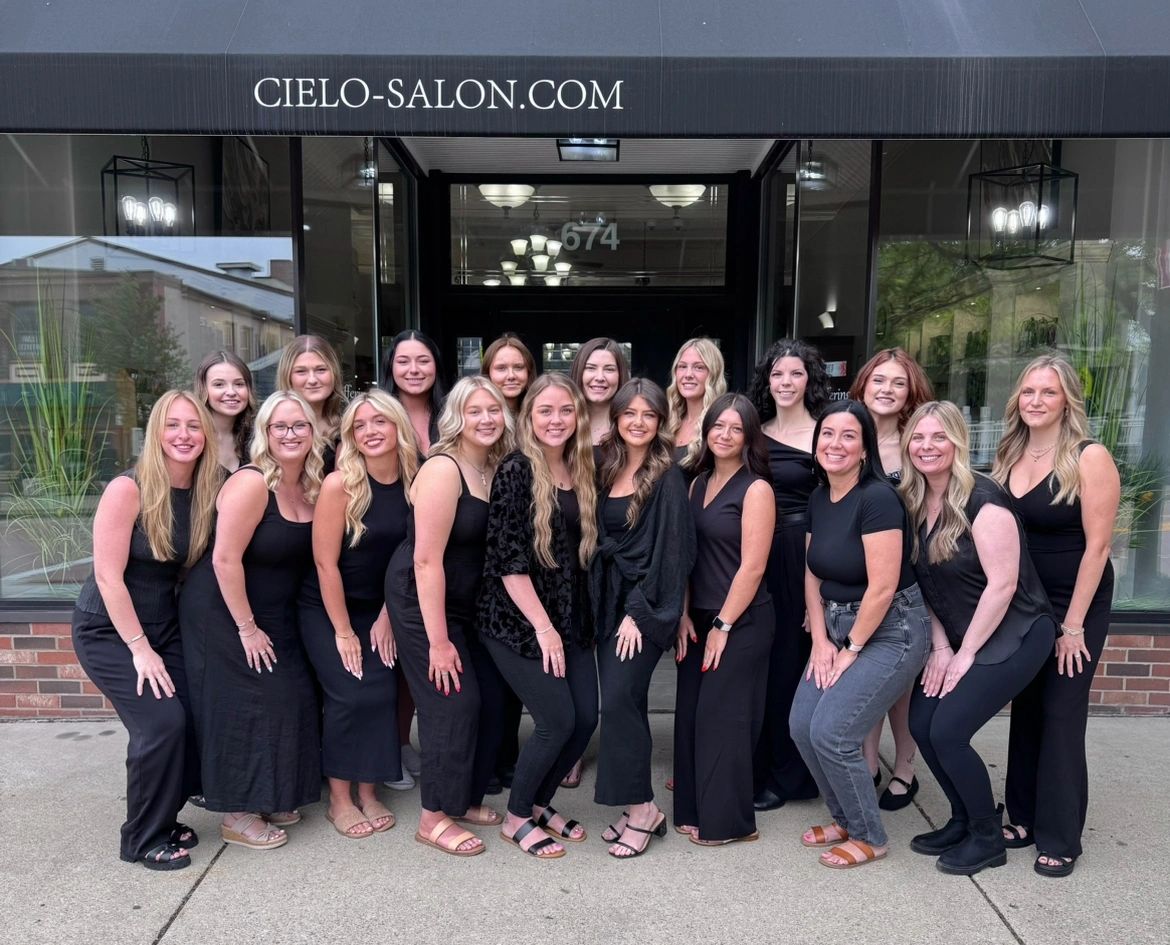 Group photo of salon staff in black outfits outside Cielo Salon.