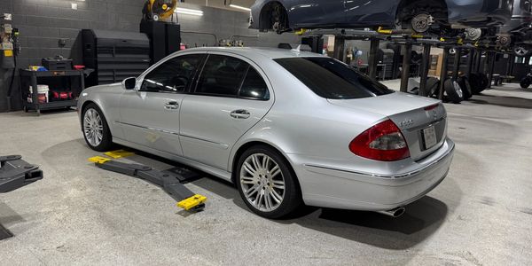 Silver Mercedes-Benz sedan parked in an auto repair shop.