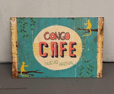 Vintage Congo Cafe sign with playful yellow monkeys on branches.