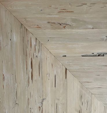 Close-up of two-tone wooden floor with diagonal joint and distressed texture.