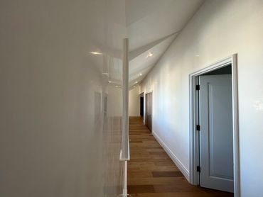 Minimalist hallway with wooden flooring and white walls.