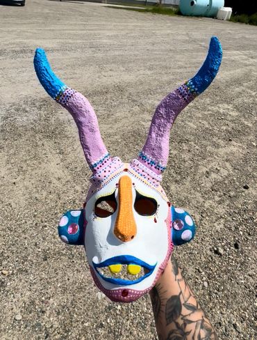 Colorful hand-painted mask with blue horns and a long nose.